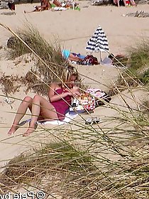 A mature woman feels that she is not being watched on a beach for nudists.
